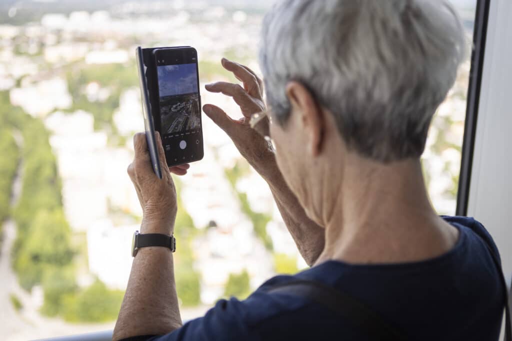 Ältere Frau nutzt ein Smartphone, um ihre Umgebung zu fotografieren