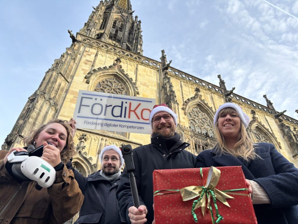 4 Personen in Münster halten technische Ausrüstung in die Kamera